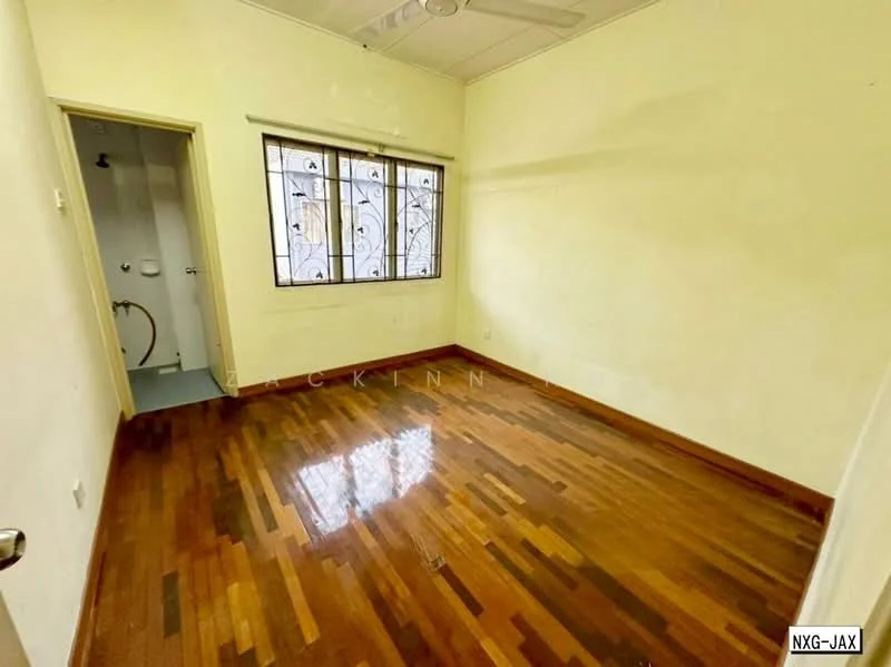 Room features: wooden flooring, cream painted walls, ceiling fan, two windows with metal grills, door leading to bathroom, light fixture on ceiling.