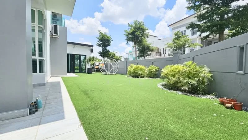 Exterior type: detached bungalow; features: manicured lawn, artificial turf, landscaped garden with shrubs, decorative stone pathway, outdoor seating area, surrounding greenery, fenced perimeter, modern facade, large windows, patio area; style: modern.