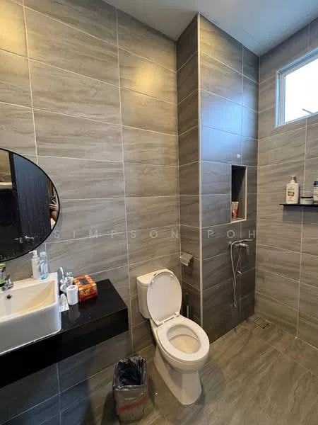 Bathroom features: grey tile cladding on walls, light grey tile flooring, round mirror above sink, white ceramic sink, black countertop, one-piece toilet, bidet spray, small window for natural light, shelf for toiletries; style: modern.