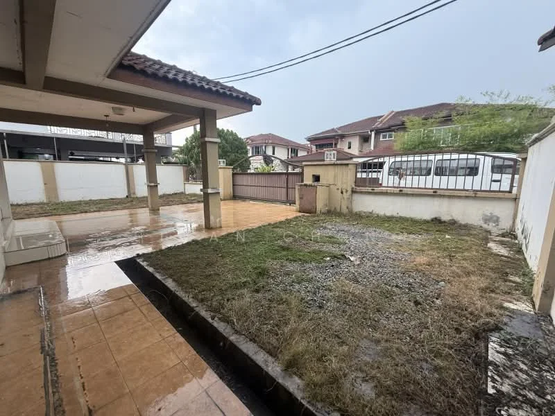Exterior type: linked terrace house; features: paved driveway, grass area, fenced perimeter, covered porch, surrounding residential houses, wet surface from rain; style: modern.