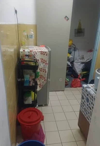Laundry features: white tiled walls, cream tiled flooring, fridge, plastic storage containers, red plastic bin, blue plastic bucket, shelf with various items, laundry basket, countertop with fabric cover.