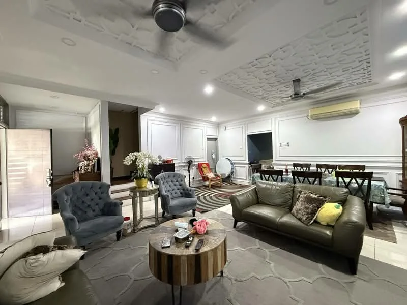 Living features: grey upholstered sofa, 3-seater leather sofa, round wooden coffee table, area rug with geometric pattern, 2 accent chairs in blue, ceiling fan with light, recessed downlights, decorative ceiling with textured design, wall-mounted air conditioning unit, wall paneling, large windows with sheer curtains, wooden dining table in background, decorative plants, wall clock; style: modern.