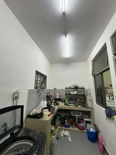 Laundry features: white painted walls, grey tiled flooring, single-bowl stainless-steel sink, wall-mounted cabinets, countertop workspace, washing machine, various kitchen utensils, open shelving, window with metal grille, fluorescent ceiling lights.