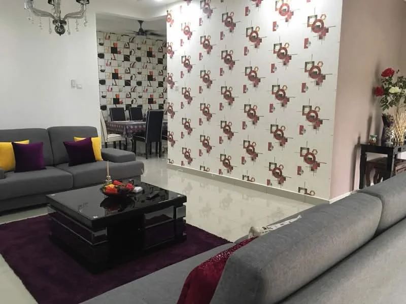 Living features: grey fabric 3-seater sofa, grey fabric 2-seater sofa, black coffee table, purple area rug, decorative wall with geometric pattern, white painted walls, recessed ceiling lights, decorative chandelier, vase with flowers, dining table visible in background, black dining chairs; style: modern.