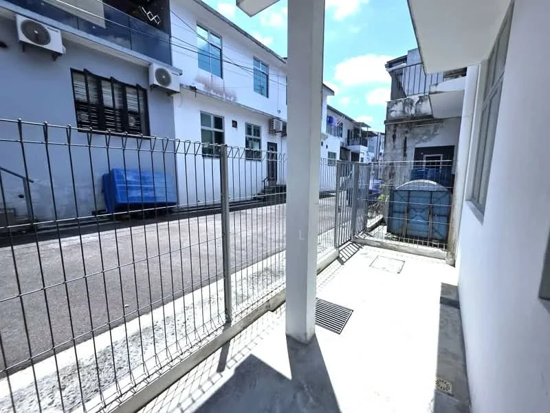 Exterior type: linked terrace house; features: fenced yard, concrete pathway, visible air conditioning units on facade, blue tarpaulin covering items, paved driveway, metal gate, adjacent buildings, street view, drainage grate; style: modern.
