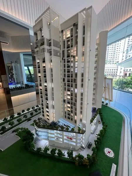 Exterior type: high-rise condominium; features: modern facade with white cladding, glass curtain wall, landscaped garden with greenery, multi-storey car park, driveway with interlocking pavers, surrounded by mature trees, outdoor lighting, balconies on upper floors; style: modern.