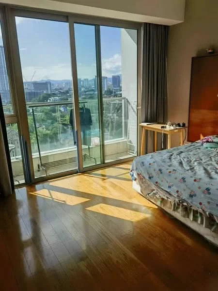 Bedroom features: wooden flooring, floor-to-ceiling windows, sliding glass door, curtains, queen-size bed with patterned bedding, wooden bedside table, decorative wall, natural light from windows; style: modern; view: city.