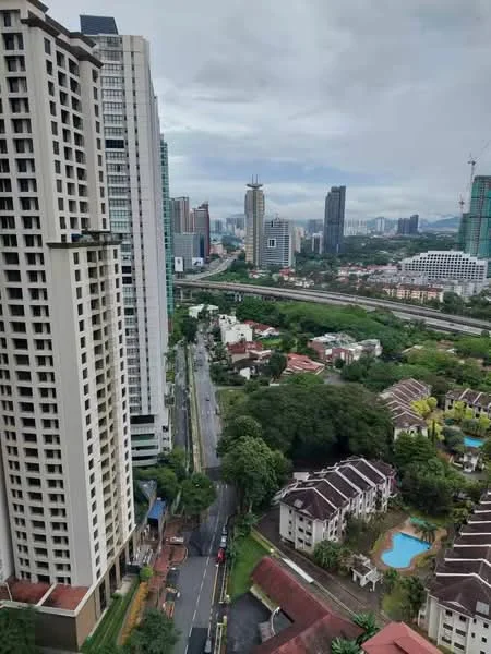 Exterior type: high-rise condominium; features: city skyline view, surrounded by greenery, near main road, multiple high-rise buildings, low-rise residential buildings, swimming pools visible in residential area, urban landscape, mixed-use development; style: modern.