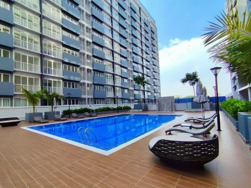 Exterior type: high-rise condominium; features: infinity pool, pool deck with loungers, landscaped garden with palm trees, glass curtain wall facade, balconies on upper floors, outdoor lighting, manicured lawn, tiled pool surround; style: modern.