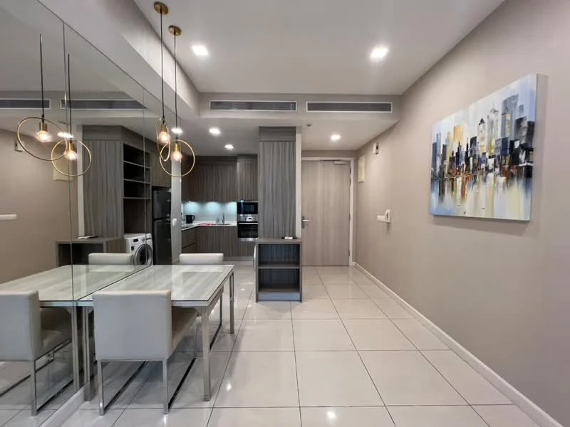 Dining features: rectangular dining table with marble top, 4 upholstered dining chairs in white, mirrored wall, pendant lighting with gold accents, recessed downlights, white tiled flooring, built-in cabinetry with wood finish, framed artwork on wall, washer-dryer combo, stainless-steel fridge, built-in microwave, kitchenette area with countertop; style: modern.