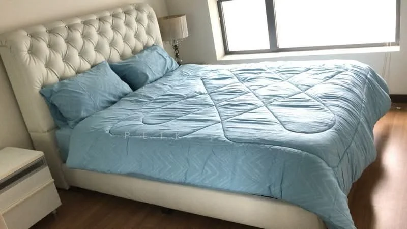 Bedroom features: king-size bed with upholstered headboard, light blue bedding, two light blue pillows, nightstand with drawer, table lamp, floor-to-ceiling window, wooden flooring, white walls; style: modern.