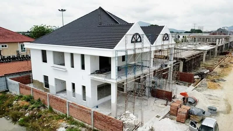 Exterior type: semi-detached house; features: white painted facade, pitched tile roof, two-storey structure, scaffolding around the building, brick wall perimeter, unfinished exterior, surrounding construction site, landscaping in progress; style: modern.