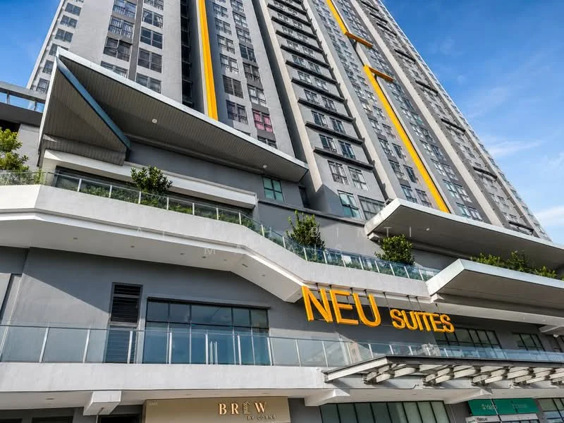 Exterior type: high-rise condominium; features: grey concrete facade, yellow accent stripes, glass balcony railings, multiple storeys, overhanging roof, landscaped planters, large signage, commercial space at ground level; style: modern.
