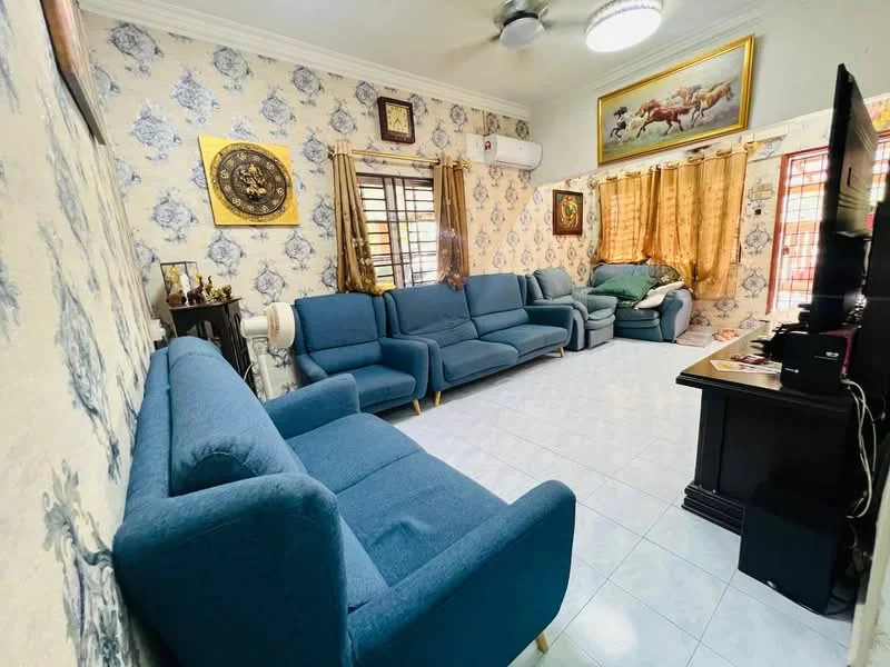 Living features: blue fabric 3-seater sofa, blue fabric 2-seater sofa, blue fabric armchair, white tiled flooring, cream wallpaper with floral pattern, gold-framed artwork on walls, window treatments with sheer curtains, ceiling fan, wall-mounted air conditioning unit, decorative wall clock, wooden TV console, black television, golden curtains; style: traditional.