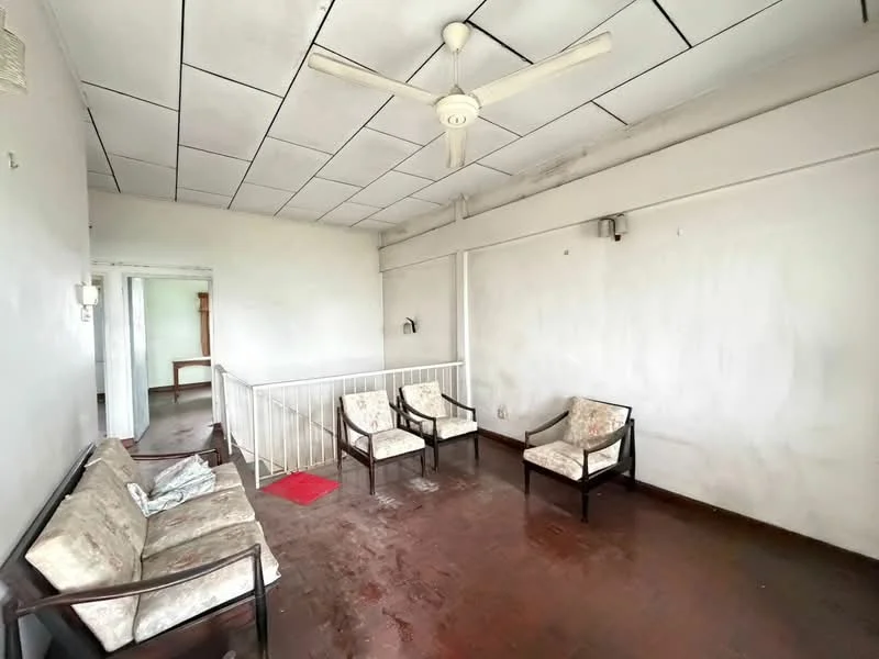 Living features: wooden flooring, white painted walls, ceiling fan, four armchairs with floral upholstery, red area rug, open layout, natural light from adjacent room, plain ceiling tiles; style: minimalist.
