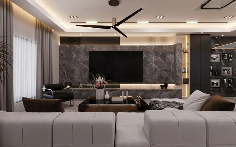 Living features: large grey marble feature wall, wall-mounted flat-screen TV, recessed LED downlights, 5-blade ceiling fan with light, light grey sectional sofa, brown leather accent chair, dark wood coffee table, decorative vase with flowers, black and white patterned throw blanket, built-in cabinetry with lighting, curtains in neutral tone, textured area rug, framed photographs on wall; style: modern.