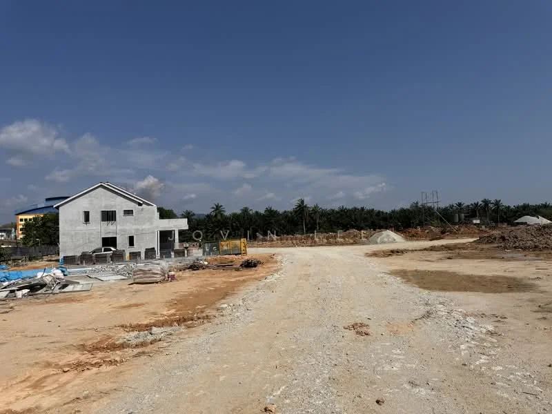 Exterior features: unfinished building structure, concrete walls, gravel road, construction debris, surrounding land, clear blue sky, palm trees in background.