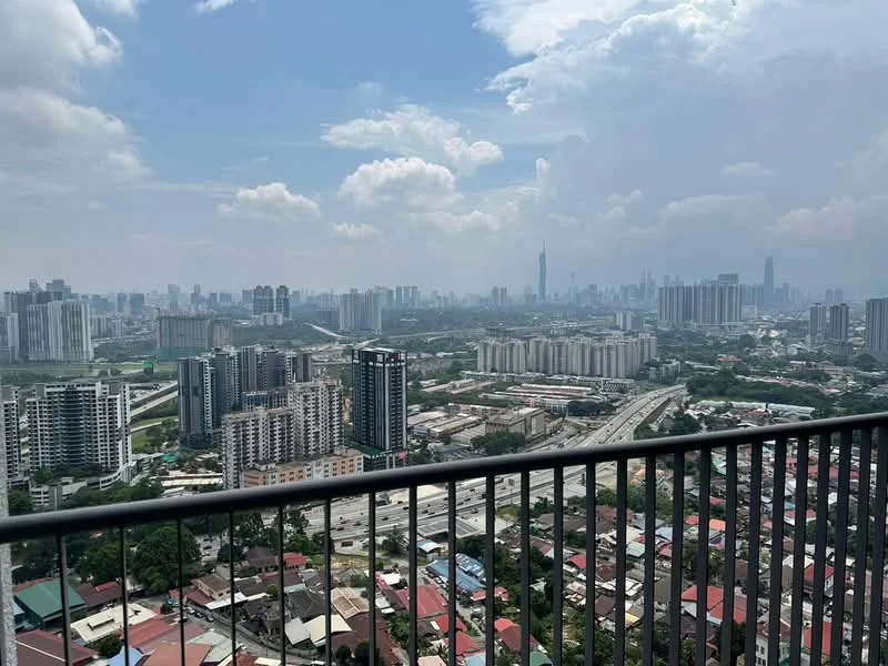 Exterior type: high-rise condominium; features: city skyline view, balcony railing, urban landscape, high-rise buildings in foreground, highway visible, cloudy sky, distant skyscrapers, mixed-use development; style: modern.
