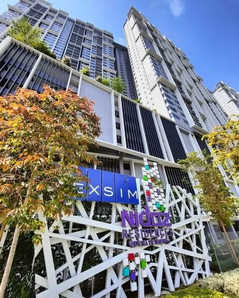 Exterior type: high-rise condominium; features: glass curtain wall, white painted facade, geometric feature wall, landscaped greenery on balconies, mature trees in foreground, colorful decorative elements on facade, multiple storeys, modern architectural design; style: contemporary.