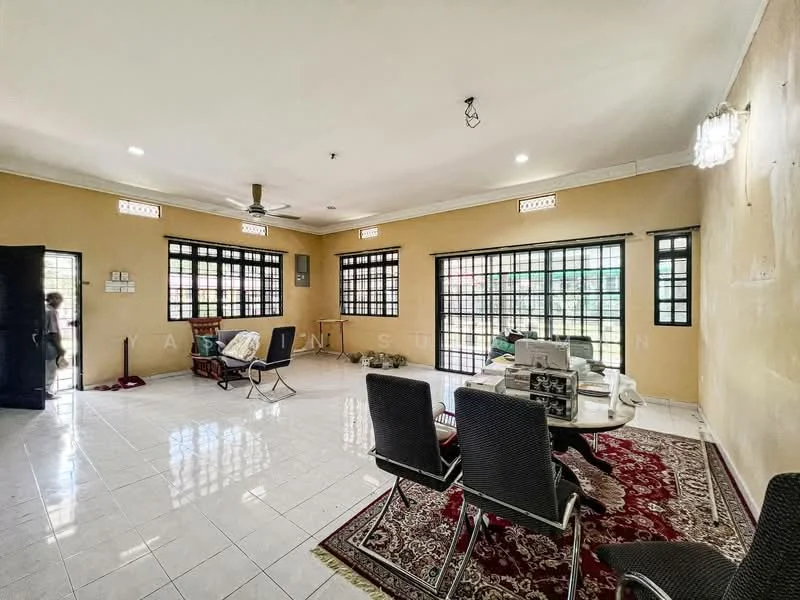 Living features: white painted walls, glossy ceramic tile flooring, 5-blade ceiling fan, large windows with black frames, double-door entrance, decorative wall sconces, area rug with floral pattern, dining table with chairs, armchair, side table; style: traditional.