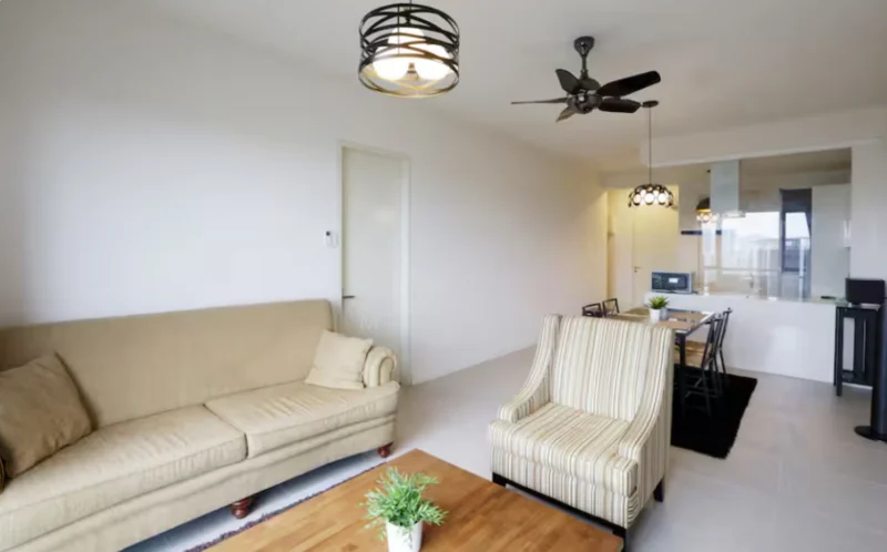 Living features: beige fabric 3-seater sofa, striped armchair, wooden coffee table, ceiling fan with 5 blades, recessed downlights, white painted walls, light-colored tiled flooring, open layout to dining area; style: modern. Dining features: 4-seater dining table, black dining chairs, pendant lighting above table, open layout to living area, kitchen visible in background; style: modern.