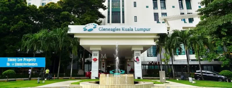 Exterior type: serviced apartment; features: modern facade with glass and concrete, water fountain at entrance, manicured lawn, palm trees, signage with 'Gleneagles Kuala Lumpur', covered entrance, surrounded by greenery, outdoor seating area; style: modern.