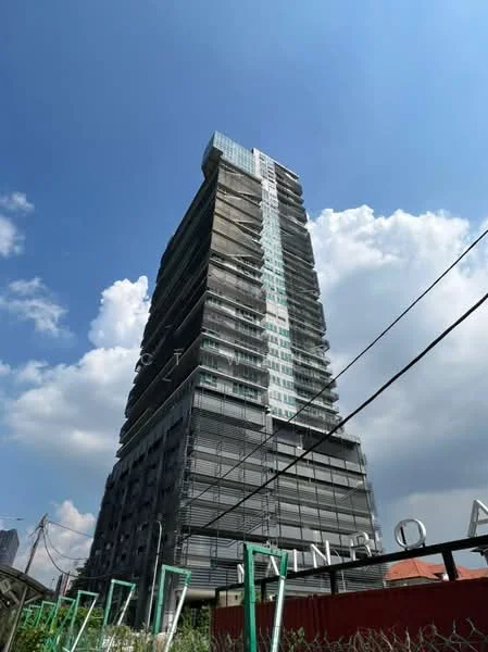 Exterior type: high-rise condominium; features: glass curtain wall, exposed concrete facade, recessed balconies, approximately 20-storey high-rise, construction scaffolding visible, modern architectural design; style: modern.