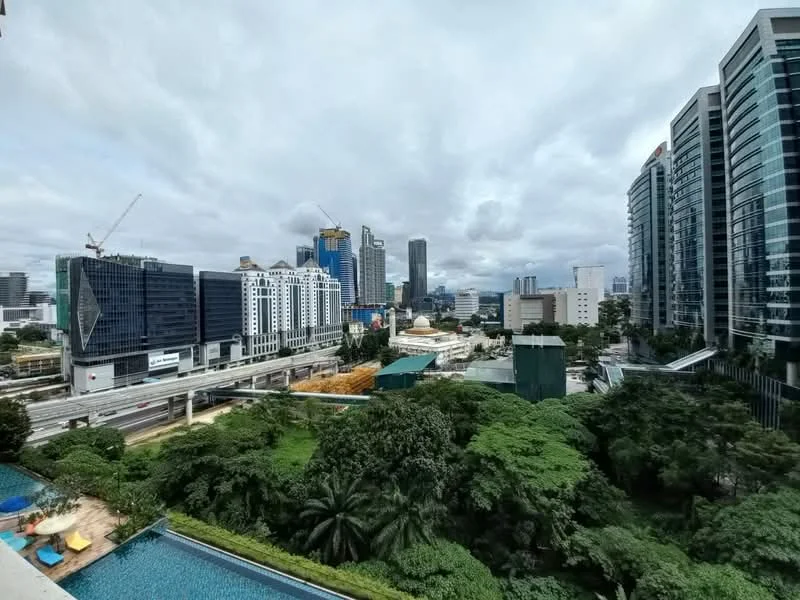 Exterior type: high-rise condominium; features: city skyline view, green landscaping, swimming pool visible, modern glass facade buildings, urban setting, construction cranes in the background, highway visible, mature trees; style: modern.