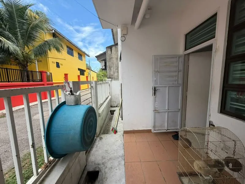 Room features: white walls, brown tiled flooring, door with glass panel, window with green frame, blue water barrel, fenced area, cage, cleaning tools visible; view: street.