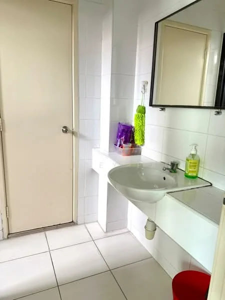 Bathroom features: white tiled walls, white tiled flooring, single-bowl sink, chrome faucet, mirror above sink, white countertop, toilet door, green cleaning supplies, soap dispenser, red stool; style: modern.