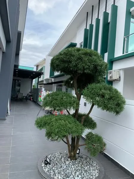 Exterior features: manicured landscaping, decorative tree with rounded foliage, stone-paved walkway, grey tiled flooring, white painted facade, green accent features on building, outdoor seating area with roof, modern architectural design; style: modern.