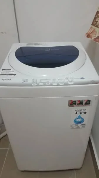 Laundry features: top-load washing machine, white appliance, control panel with buttons, transparent lid.