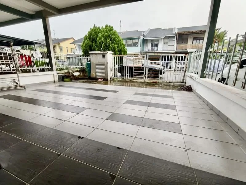 Exterior type: linked terrace house; features: paved flooring with grey and white tiles, covered porch area, fenced perimeter, green shrubbery, visible parked cars, air conditioning unit, drainage system, outdoor space with potential for landscaping; style: modern.