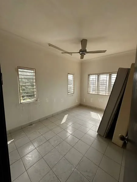 Room features: white painted walls, tile flooring, 5-blade ceiling fan, two windows with horizontal slats, natural light from windows, empty space, corner with stacked mattresses.