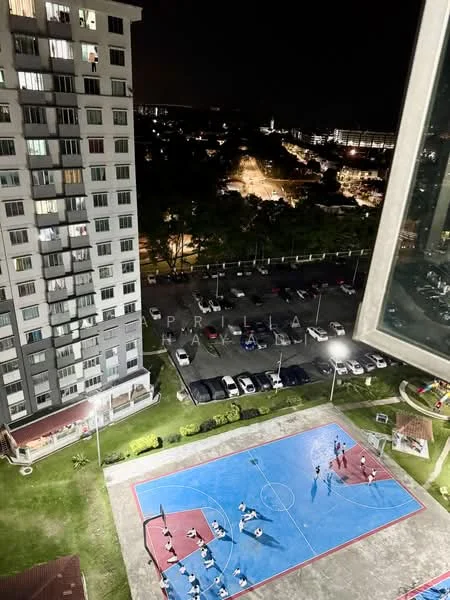 Exterior type: high-rise condominium; features: basketball court, outdoor lighting, parking lot with visible cars, manicured lawn, surrounding greenery, nighttime city view; style: modern.