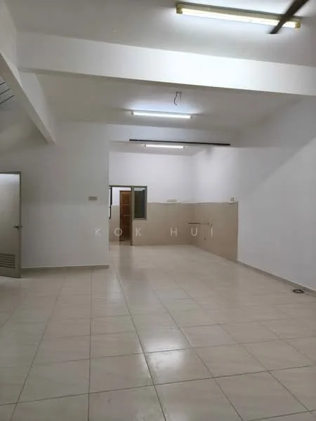 Room features: white painted walls, tile flooring, fluorescent ceiling lights, open layout, neutral color scheme, corner space, no visible furniture, large empty area; style: minimalist.