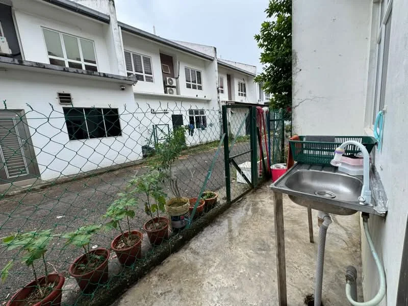 Exterior type: linked terrace house; features: fenced outdoor area, concrete flooring, outdoor sink with tap, potted plants along the fence, two-storey building in background, windows visible on adjacent buildings, greenery in the vicinity; style: modern.