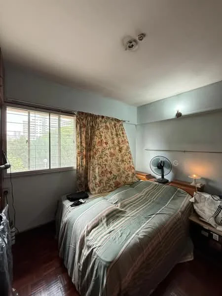Bedroom features: queen-size bed with green bedding, wooden headboard, curtains with floral pattern, floor-to-ceiling window, wooden flooring, wall-mounted light fixture, table lamp, fan, built-in shelving, decorative wall shelf; view: city.