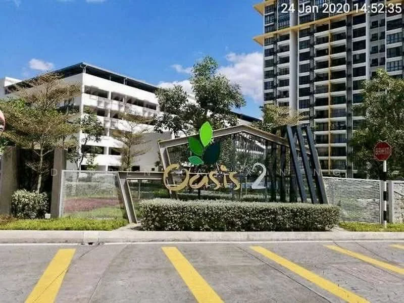 Exterior type: high-rise condominium; features: modern facade with glass and concrete, landscaped entrance with greenery, prominent signage with logo, paved driveway, surrounded by trees, clear blue sky, yellow pedestrian crossing lines; style: modern.
