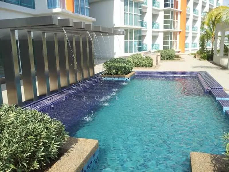 Exterior type: swimming pool deck; features: infinity edge pool, water feature with wall-mounted fountains, blue mosaic tile lining, surrounding landscaped garden with shrubs, paved walkway around the pool, sun loungers area, tropical palm trees in vicinity; style: modern.