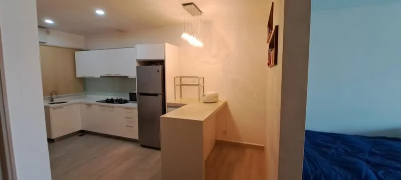 Kitchen features: white cabinetry, stainless-steel fridge, built-in oven, 4-burner gas hob, single-bowl stainless-steel sink, chrome pull-down faucet, white countertop, pendant lighting, vinyl plank flooring; style: modern. Room features: blue bedding, wall with light color paint, unknown furniture.