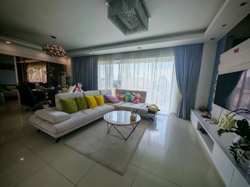 Living features: L-shape sectional sofa in white, decorative cushions in various colors, glass coffee table, area rug, floor-to-ceiling windows, sheer curtains, blue drapes, wall-mounted TV, entertainment unit, chandelier with crystals, recessed downlights, marble tile flooring; style: modern; view: city.