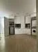 Kitchen features: white shaker cabinets, stainless-steel fridge, built-in oven, freestanding range oven, microwave, single-bowl stainless-steel sink, chrome pull-down faucet, quartz countertop, tile backsplash, washer-dryer combo, light wood flooring, recessed downlights, open layout; style: modern.