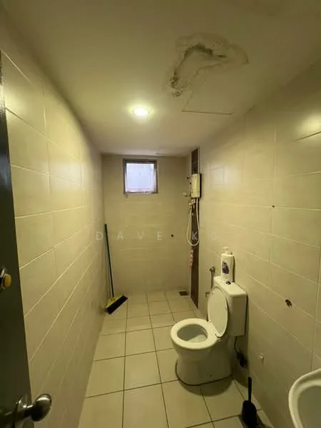 Bathroom features: white tiled walls, cream tiled flooring, one-piece toilet, small window, ceiling light, shower area, plumbing fixtures visible, cleaning supplies, exposed ceiling, water heater, squeegee.