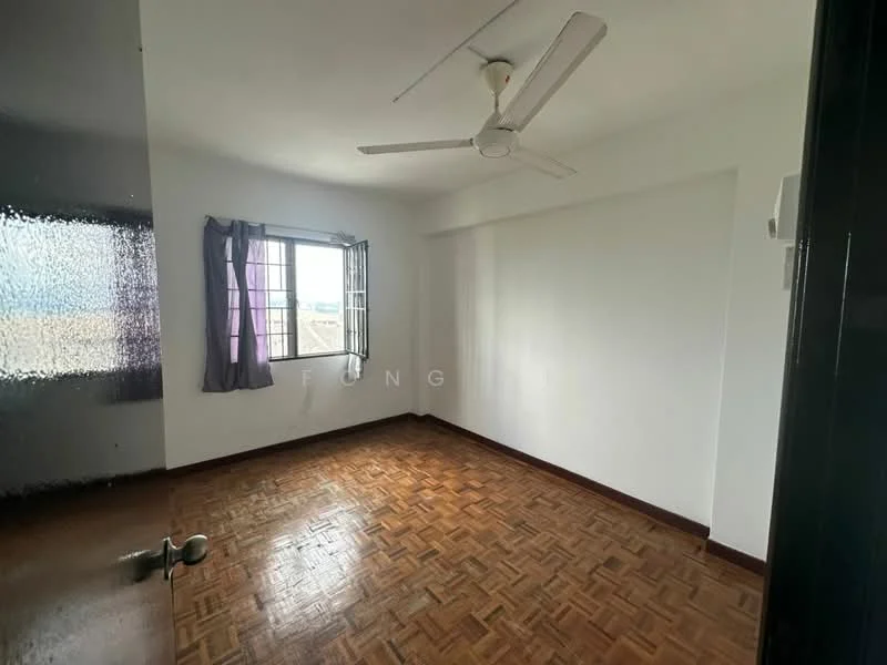 Room features: wooden parquet flooring, white painted walls, ceiling fan, window with metal grille, curtains in purple, corner of room with door, natural light from window.