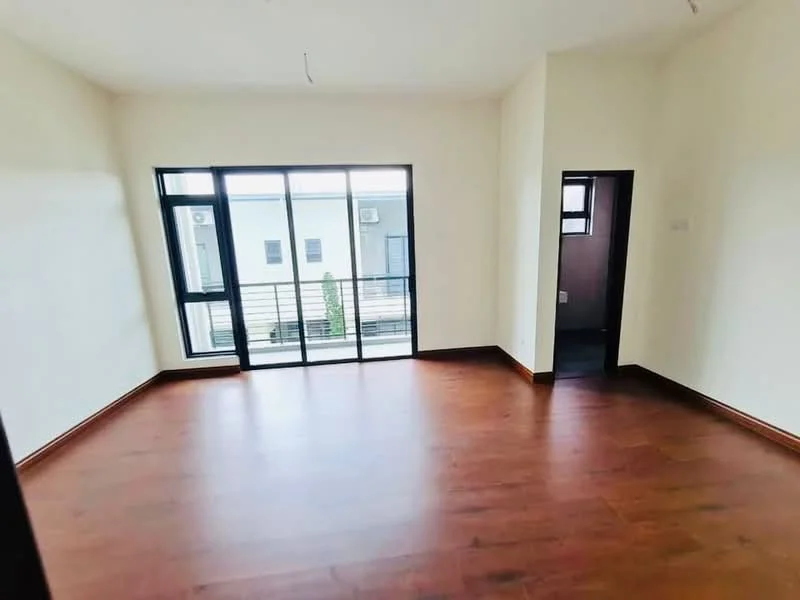 Room features: light wood laminate flooring, white painted walls, floor-to-ceiling windows, black window frames, balcony access, doorway leading to another room, minimalist design, natural light; style: modern; view: courtyard.