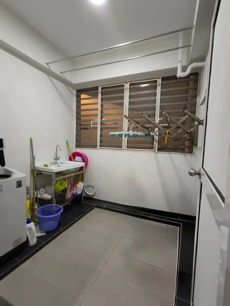 Laundry features: white painted walls, grey tiled flooring, single-bowl stainless-steel sink, metal drying rack, window with horizontal slats, washing machine, plastic laundry basket, cleaning supplies on shelf.