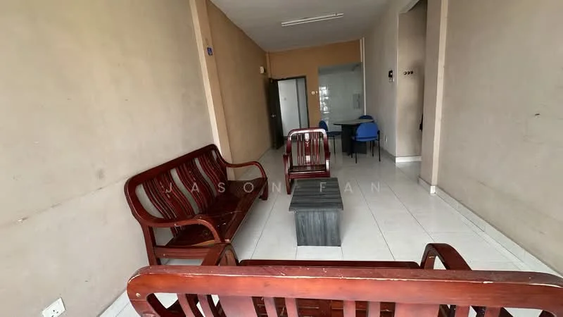 Living features: white tiled flooring, cream painted walls, wooden sofa set with armrests, wooden coffee table, single blue chair, recessed ceiling lights, doorway leading to another room.