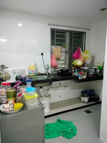 Kitchen features: white tiled walls, grey countertop, single-bowl stainless-steel sink, chrome pull-down faucet, built-in stove, microwave, refrigerator, various kitchen utensils, plastic storage containers, cooking pots, kitchen towels, green fabric on the floor.