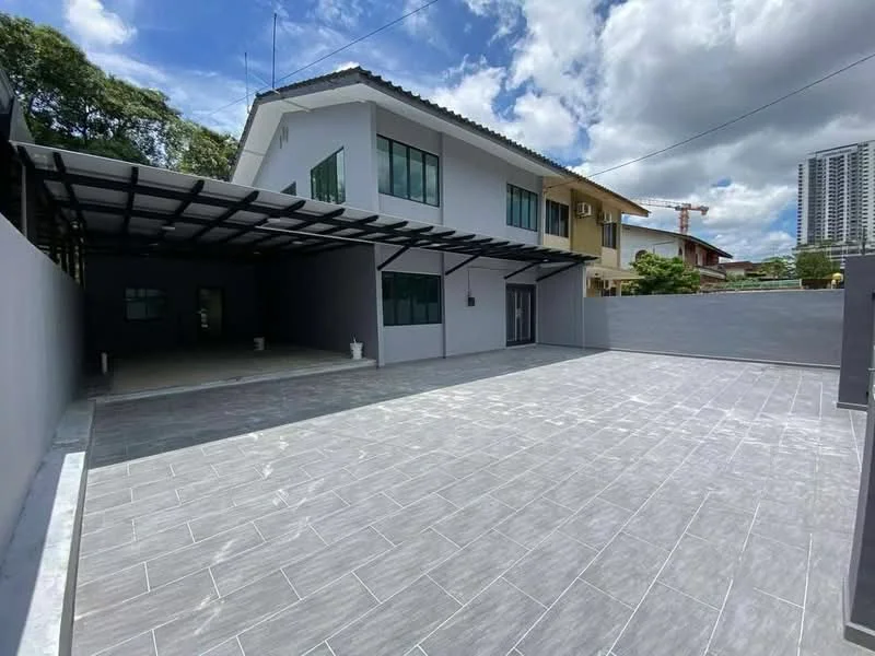 Exterior type: detached bungalow; features: grey tiled flooring, flat roof, large windows, covered carport, manicured lawn, surrounded by greenery, concrete wall, open space, urban context, two-storey structure; style: modern.